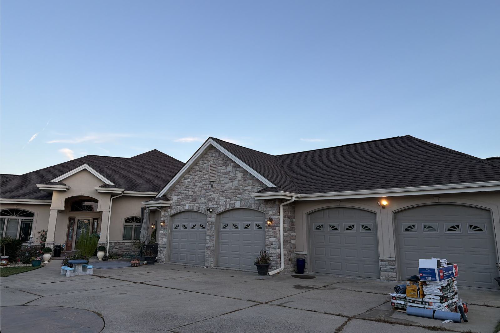 Finished dark architectural shingle roof on the same large stone home