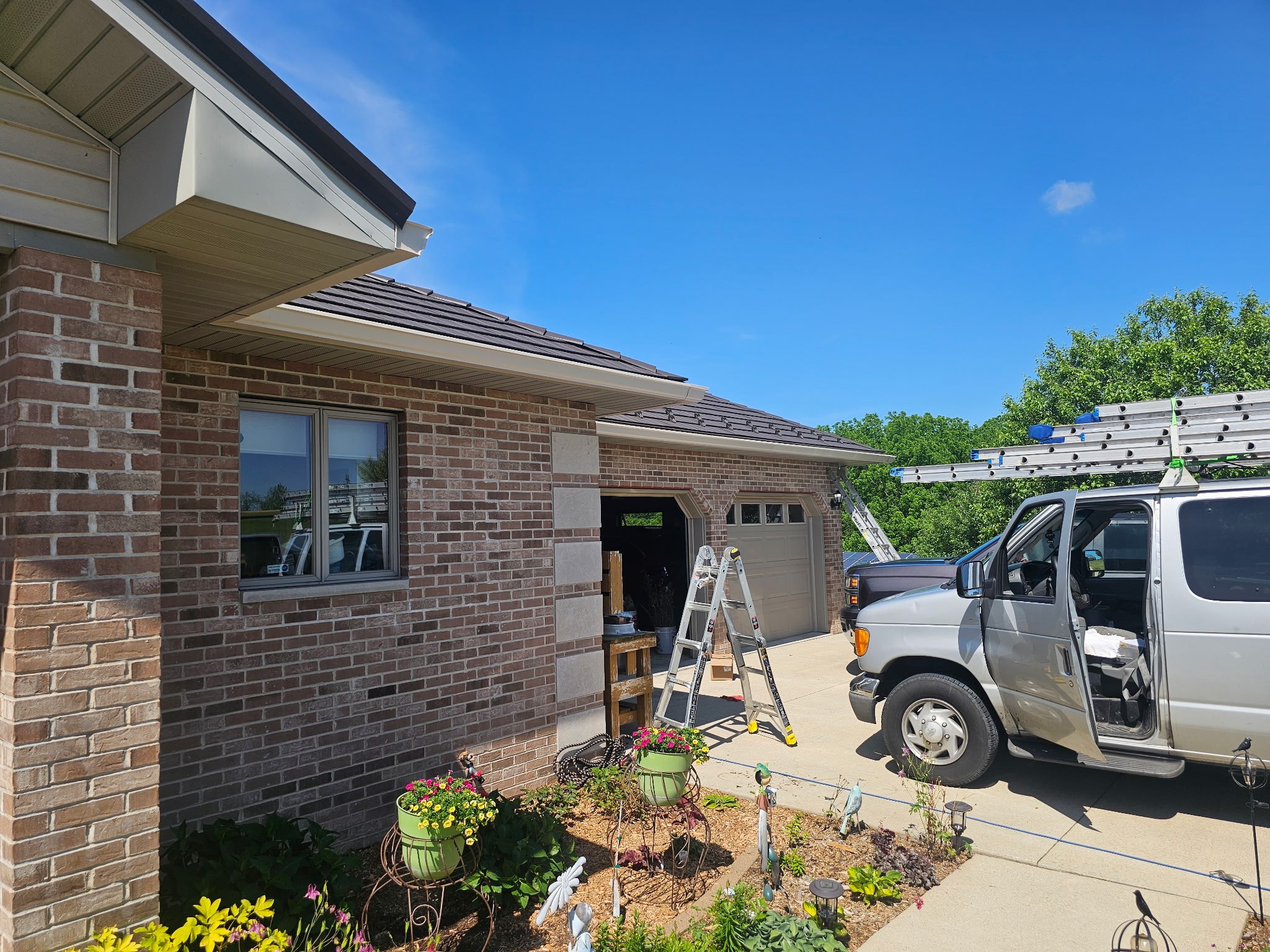 The GutterForge crew on a real install, ladders up, van in the driveway