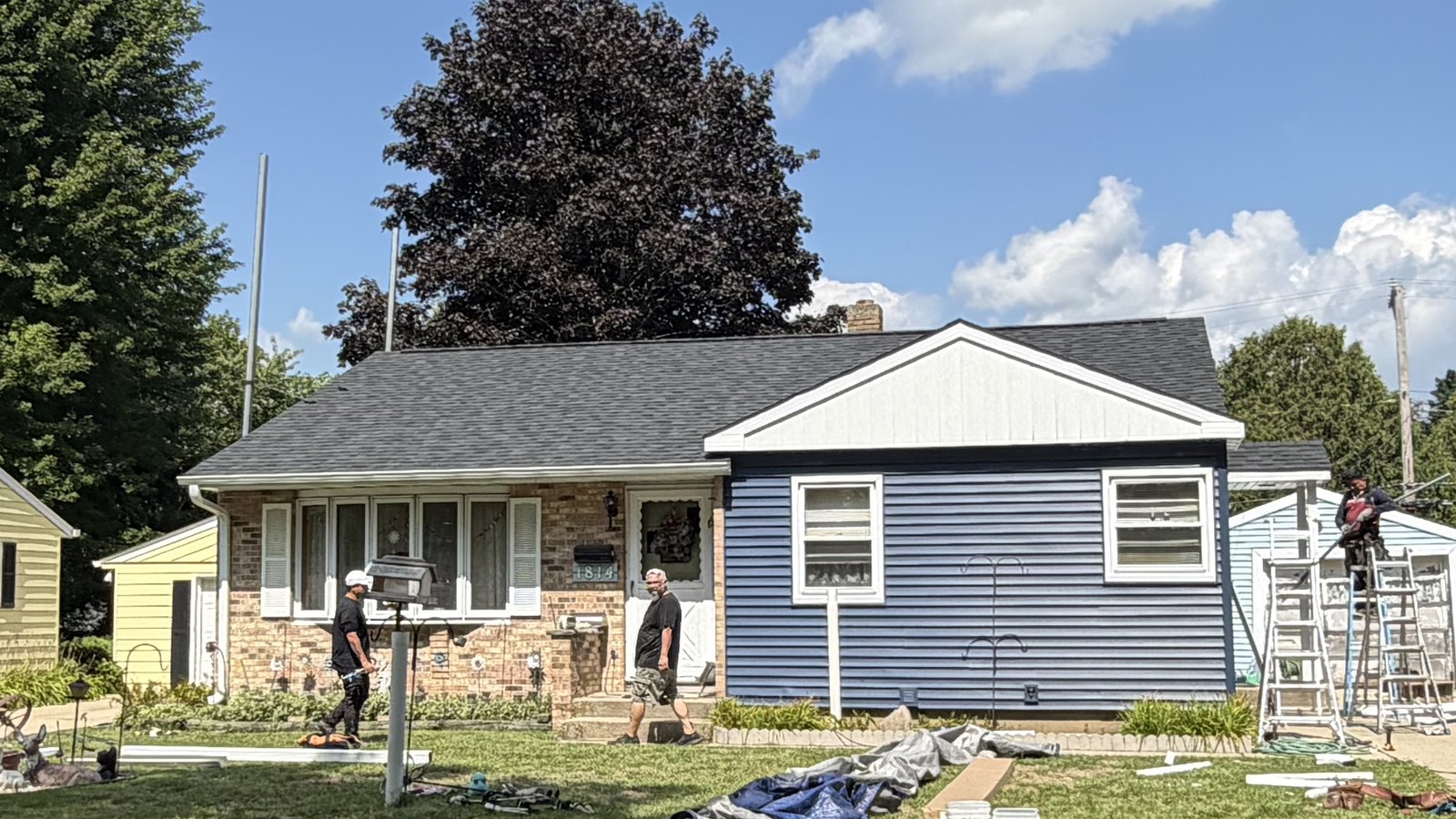 After: deep navy siding, white soffit and fascia, wrapped windows
