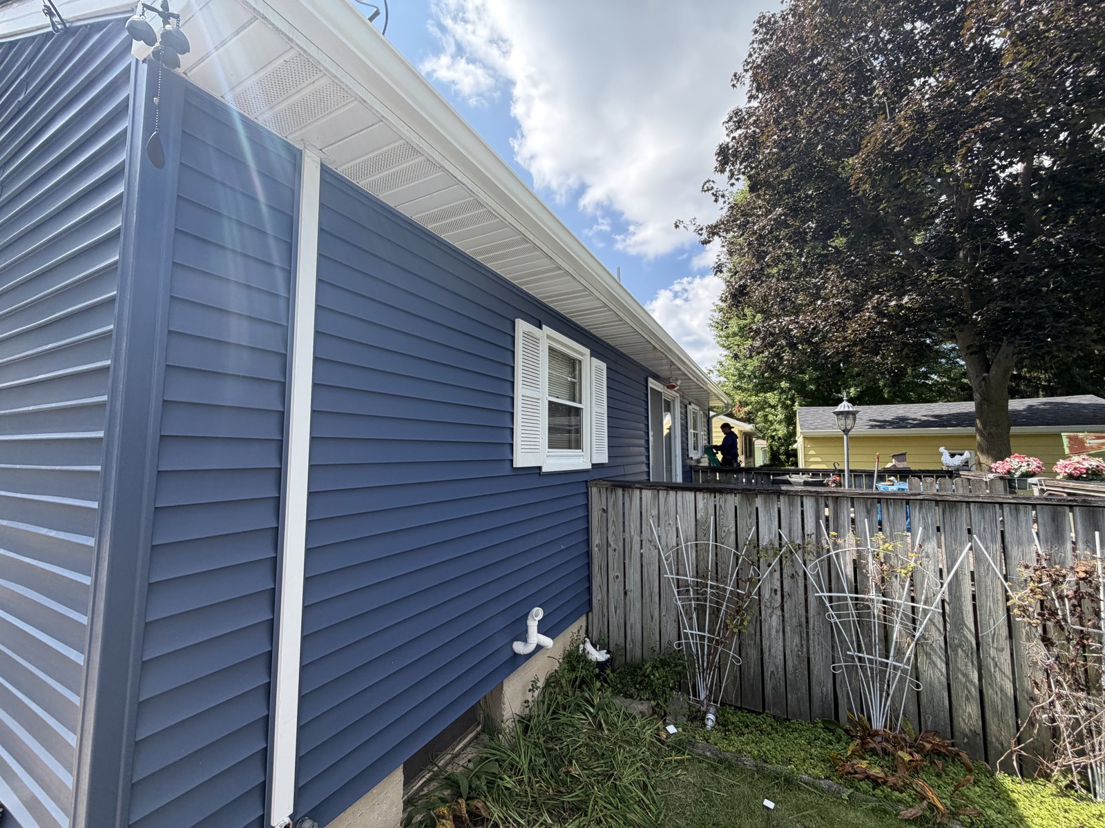 Navy siding, white soffit and fascia — the full flip